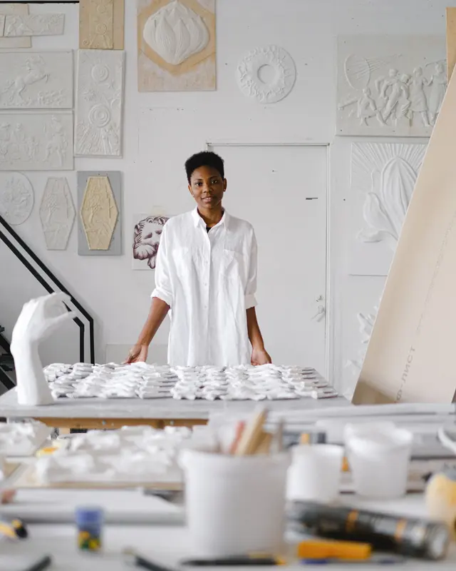 Artist standing at a worktable in a plaster studio